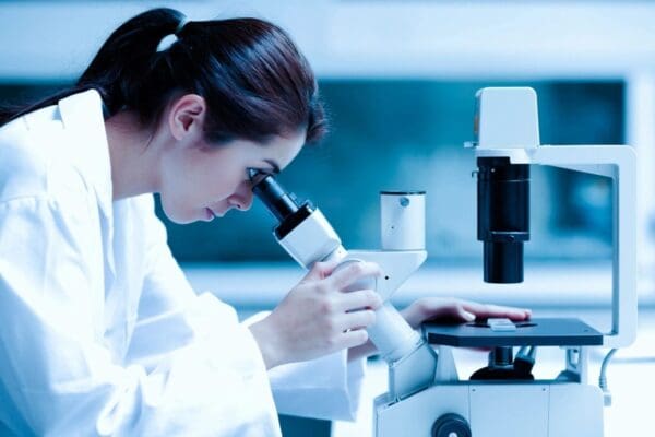 Scientist using a microscope in a lab.