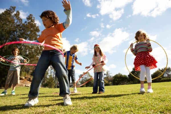 Kids playing with hoops outdoors.